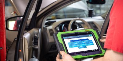 Car dashboard showing an illuminated check engine warning light on the instrument panel.